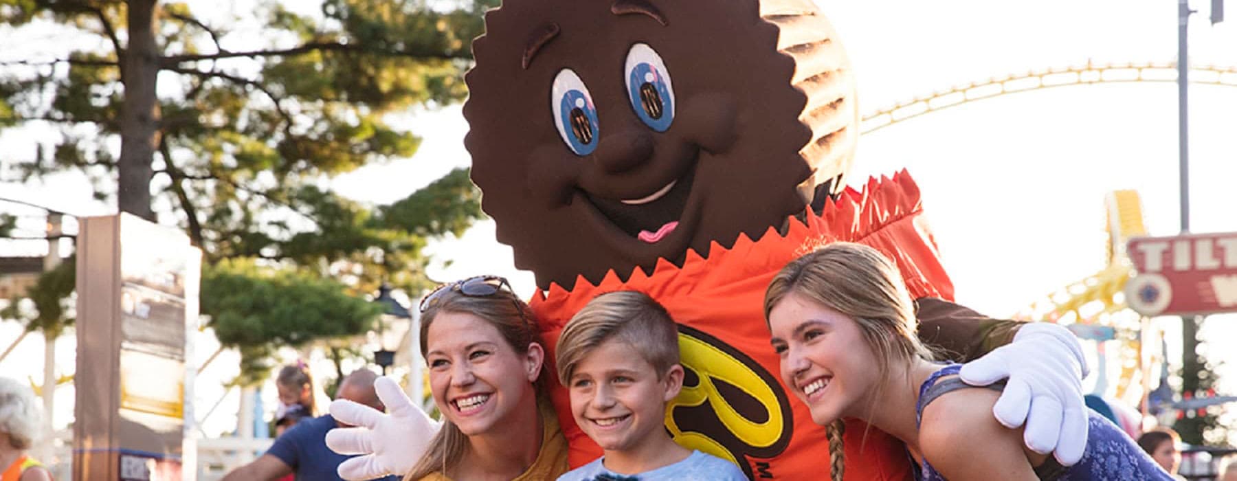 Life-sized Reese's Peanut Butter Cup character smiling for picture with children