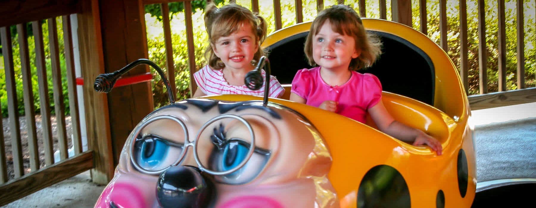 2 adorable littler girls riding the granny bug ride at Hersheypark