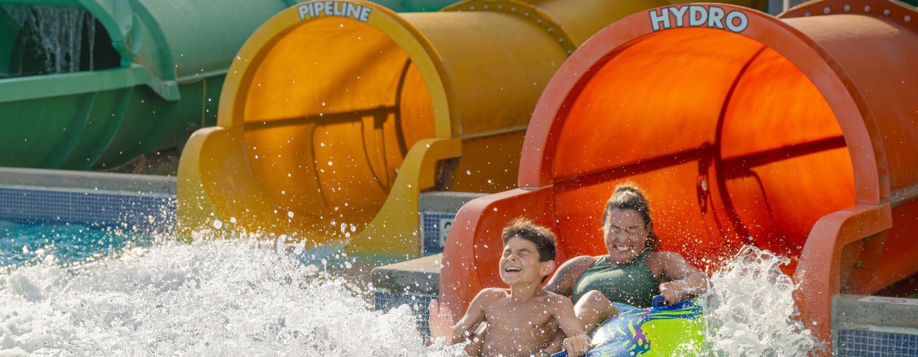 Boy and Mom coming out of the bottom of coastline plunge hydro water slide