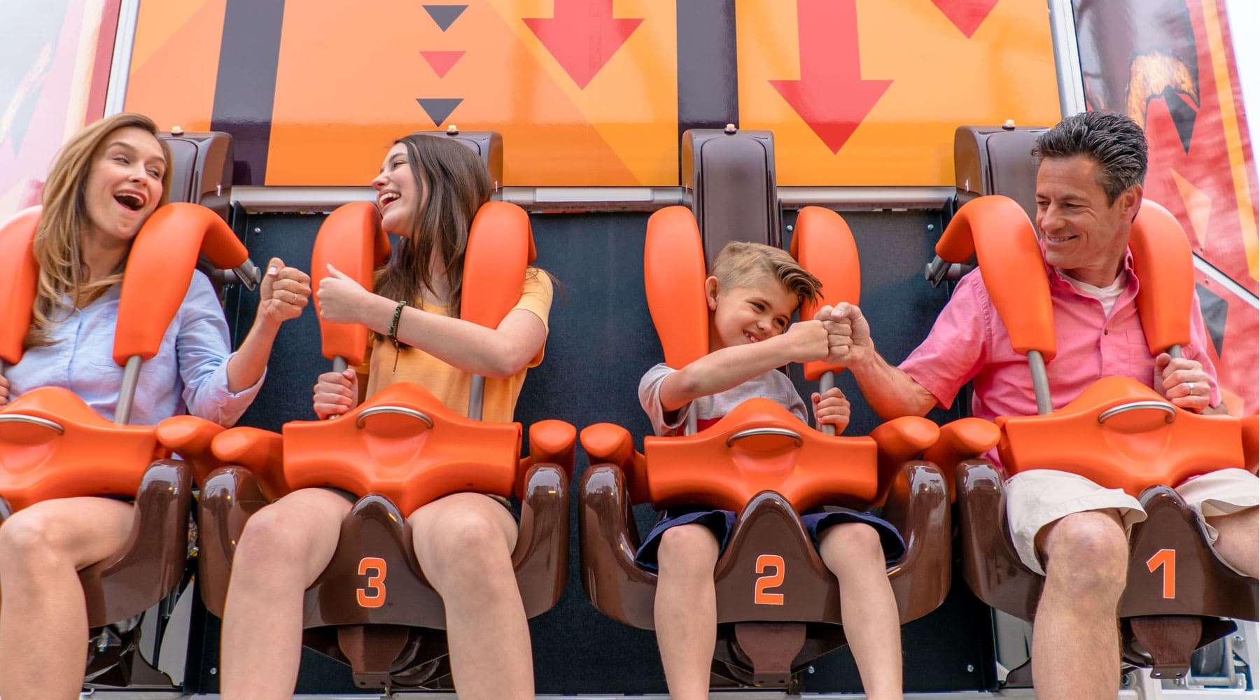 Family of four fist bumping eachother before their ride on Hersheys Triple Tower