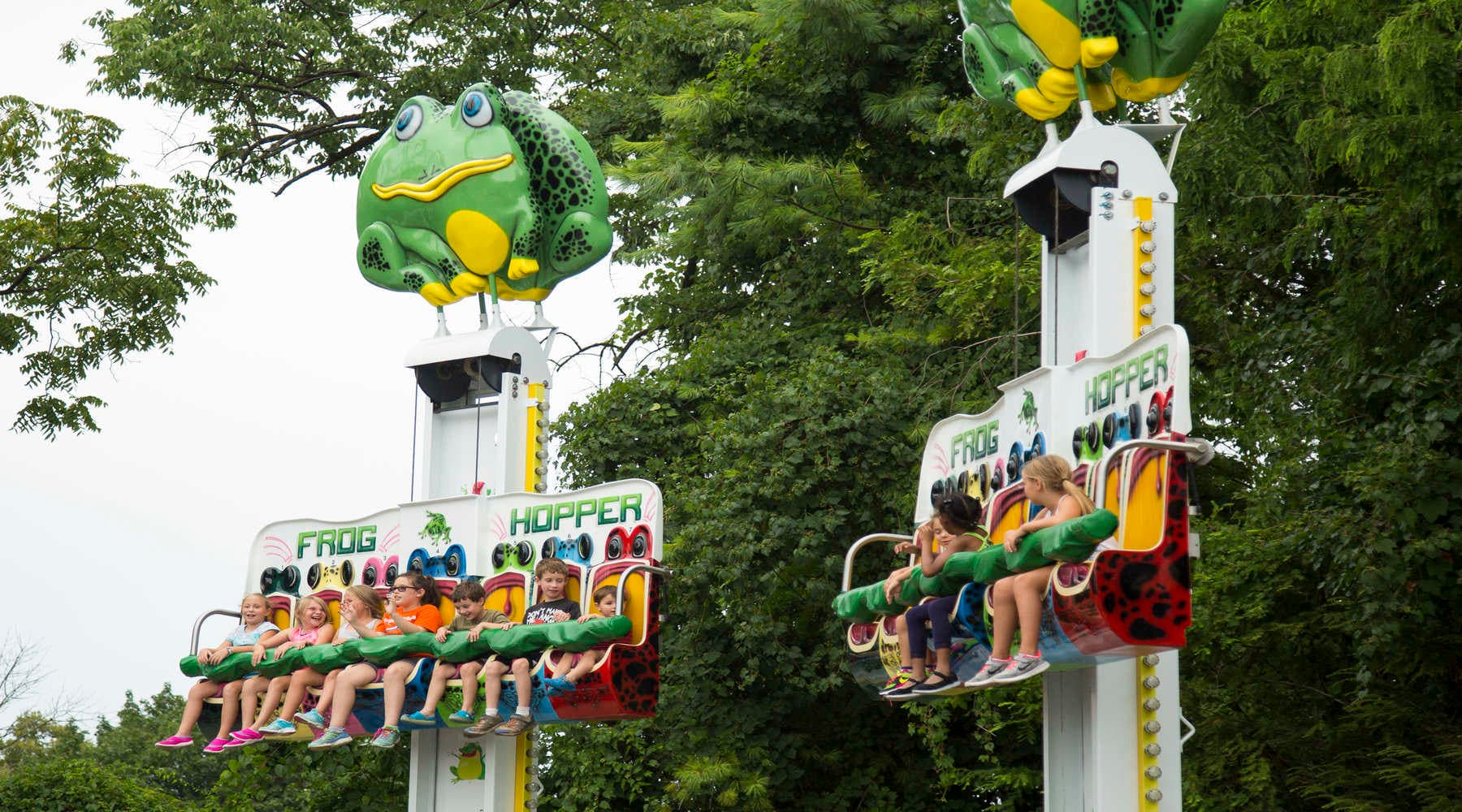 Children riding the frog hopper ride looking excited