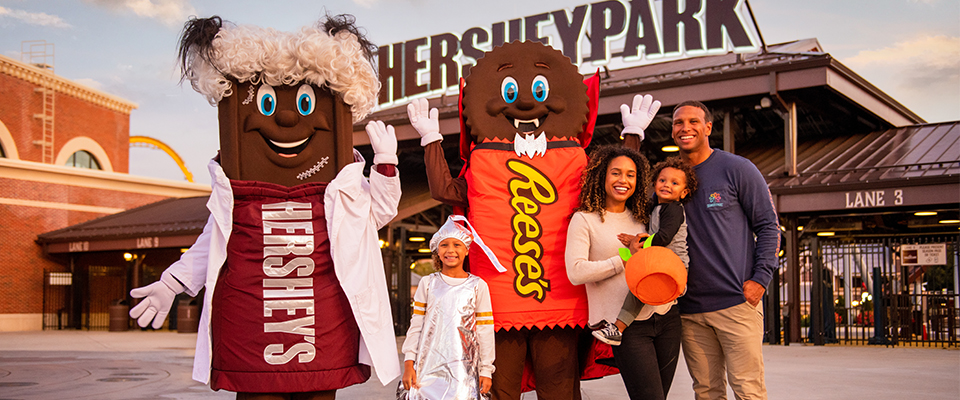 Family with Hershey Bar mascot and Reese's mascot during Hersheypark Halloween