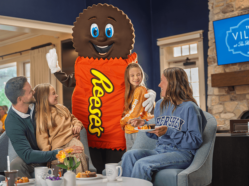 A family sitting on a bed at a Hershey Resort