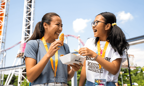 Two people eating while walking through Hersheypark